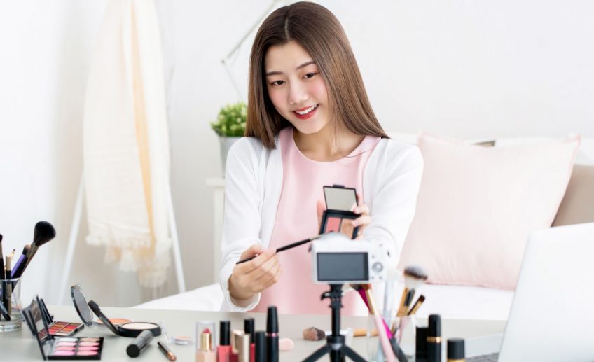 Azjatka prezentuje kosmetyki koreańskie w swoim pokoju.